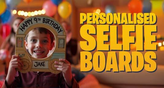 a boy holds a train shaped selfie board at his birthday party